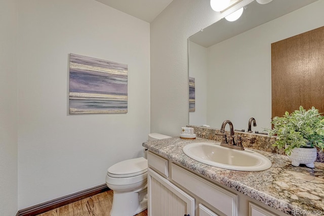 302 Northridge Rd, Highlands Ranch, CO 80126 - half bath with vanity, toilet, wood finished floors, and baseboards