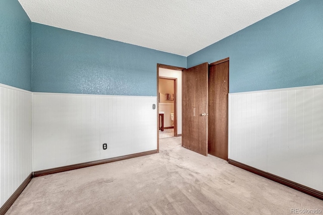 302 Northridge Rd, Highlands Ranch, CO 80126 - unfurnished bedroom with a textured ceiling, a textured wall, carpet, and baseboards