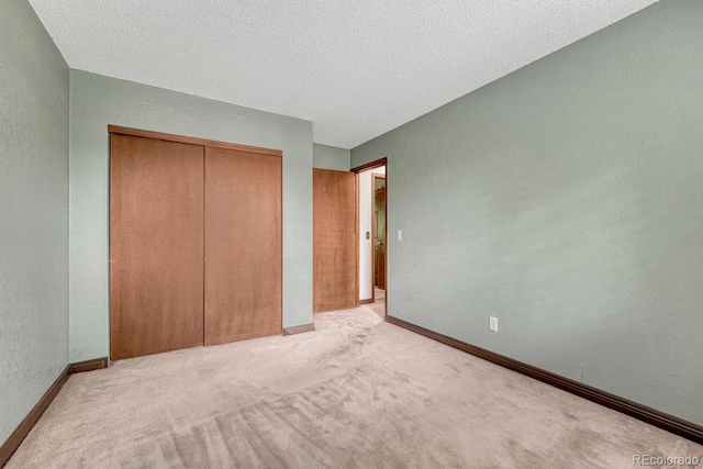 302 Northridge Rd, Highlands Ranch, CO 80126 - unfurnished bedroom featuring a closet, carpet floors, baseboards, a textured ceiling, and a textured wall