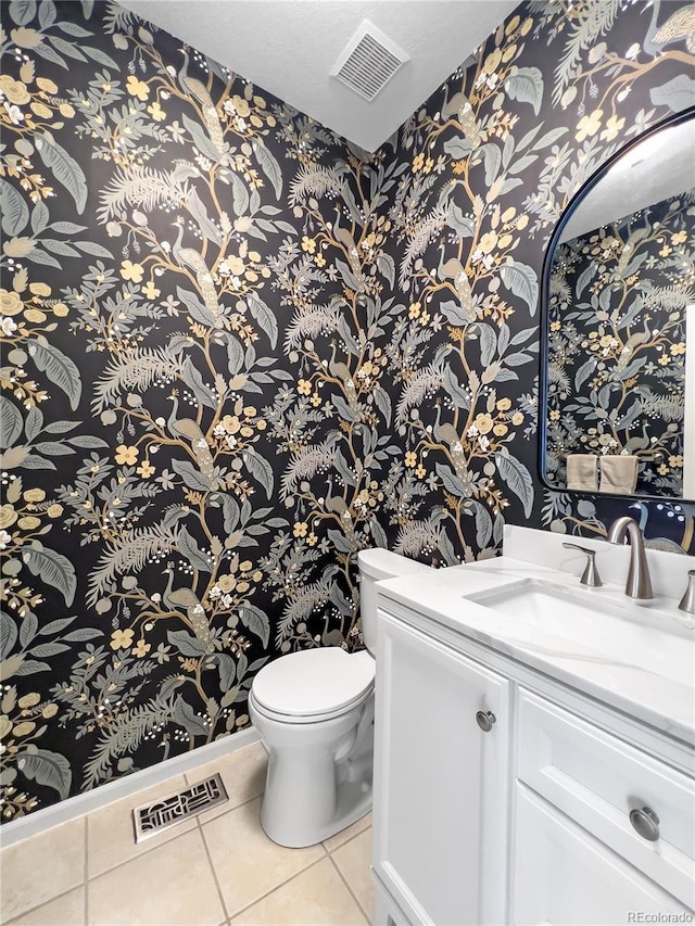 bathroom featuring vanity, tile patterned floors, and toilet