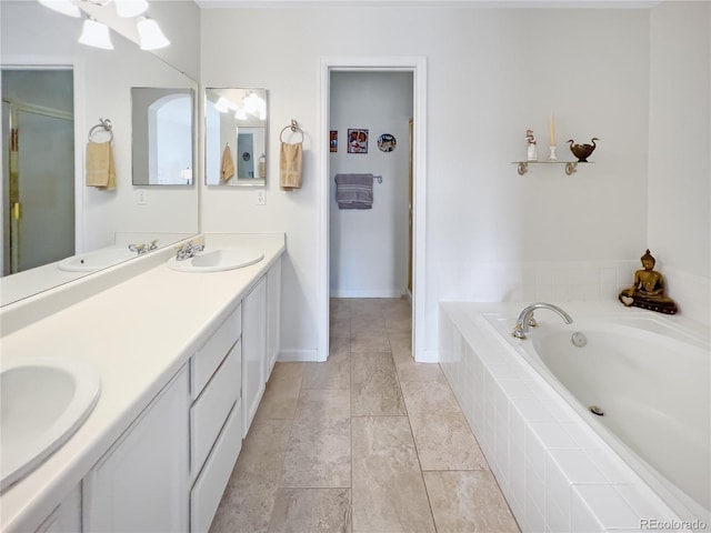 bathroom featuring a relaxing tiled tub and vanity