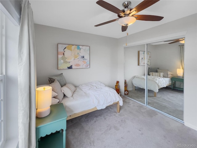 carpeted bedroom featuring ceiling fan and a closet