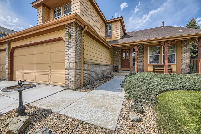 9001 W Chatfield Dr, Littleton, CO 80128 - view of front facade featuring brick siding and an attached garage