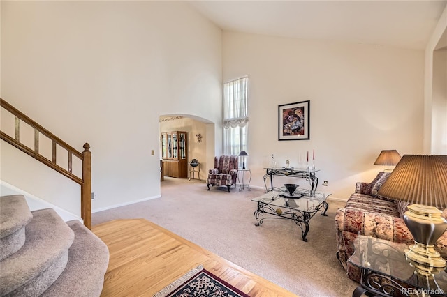 9001 W Chatfield Dr, Littleton, CO 80128 - carpeted living room with high vaulted ceiling, arched walkways, stairway, and baseboards