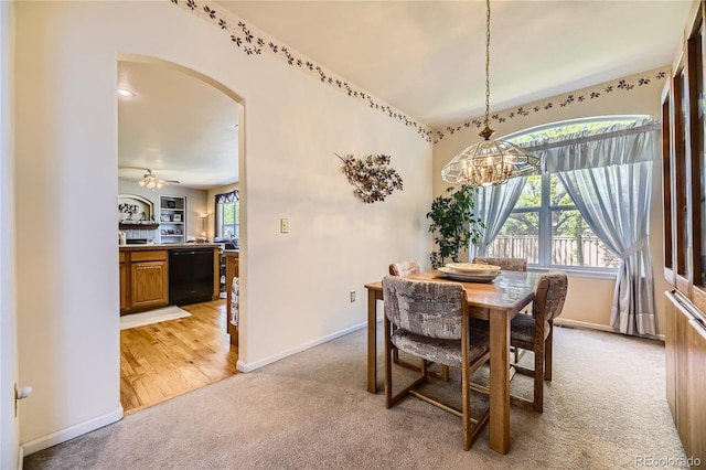 9001 W Chatfield Dr, Littleton, CO 80128 - dining area featuring light carpet, a chandelier, arched walkways, and baseboards