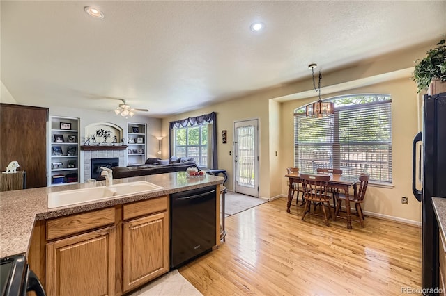 9001 W Chatfield Dr, Littleton, CO 80128 - kitchen with black appliances, a sink, a fireplace, light wood-type flooring, and open floor plan