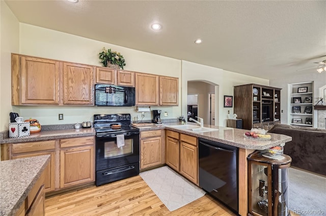 9001 W Chatfield Dr, Littleton, CO 80128 - kitchen featuring black appliances, open floor plan, arched walkways, a sink, and a peninsula