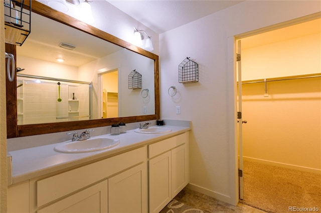 bathroom with a shower with door and vanity