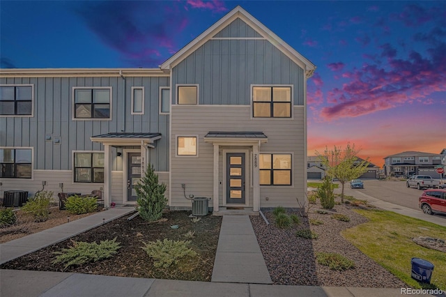 townhome / multi-family property featuring board and batten siding and central AC