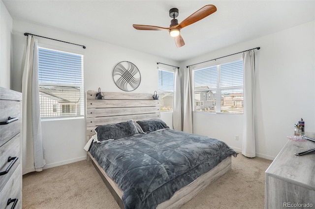 bedroom featuring a ceiling fan, baseboards, and light colored carpet