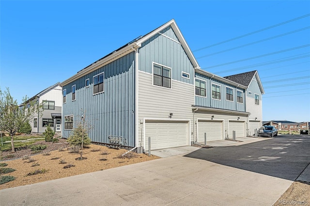 view of side of property with board and batten siding, driveway, and a garage