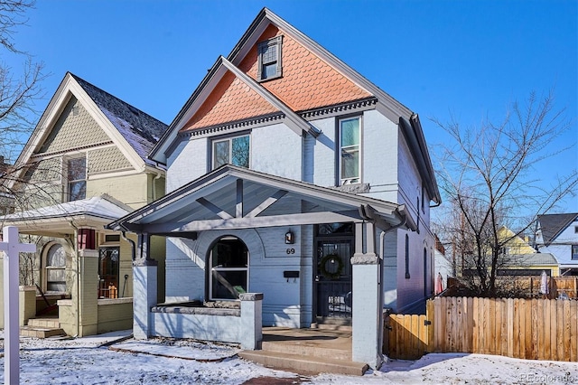 victorian house featuring fence and brick siding