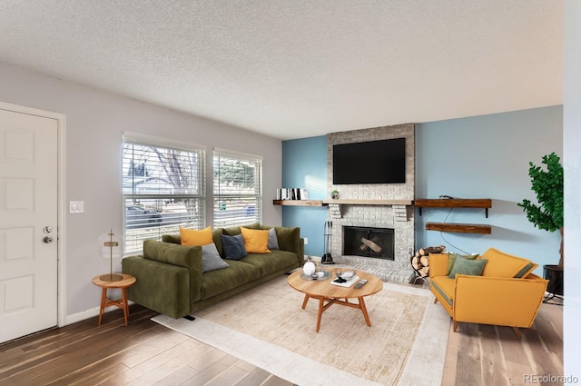 living room with a fireplace, wood-type flooring, and a textured ceiling