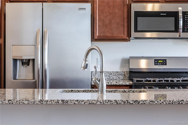 4605 Copeland Loop Unit 103, Highlands Ranch, CO 80126 - kitchen view of stainless steel appliances, stone counters, and a sink