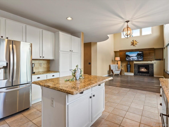 10216 Kleinbrook Way, Highlands Ranch, CO 80126 - kitchen with stainless steel refrigerator with ice dispenser, light tile patterned floors, open floor plan, white cabinetry, and recessed lighting