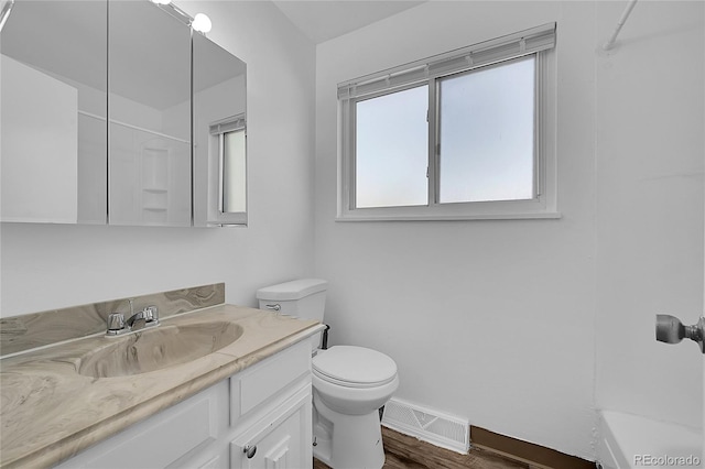 bathroom with vanity, hardwood / wood-style flooring, toilet, and walk in shower