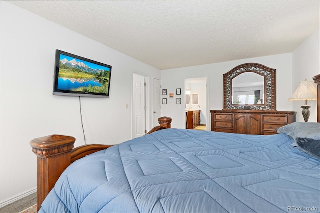 bedroom featuring a textured ceiling, carpet, and connected bathroom