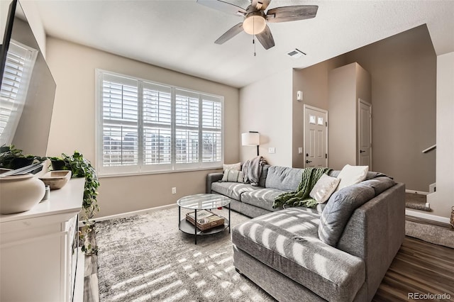 living area with visible vents, baseboards, wood finished floors, and a ceiling fan