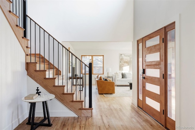 entryway featuring stairs, wood finished floors, and baseboards