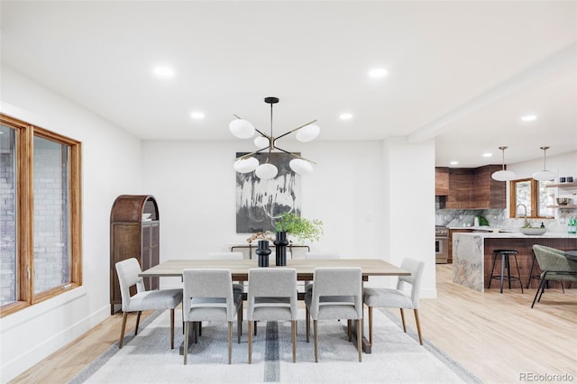 dining space with baseboards, a notable chandelier, light wood-style floors, and recessed lighting