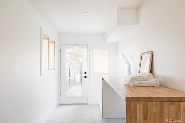 entryway with baseboards and light tile patterned flooring