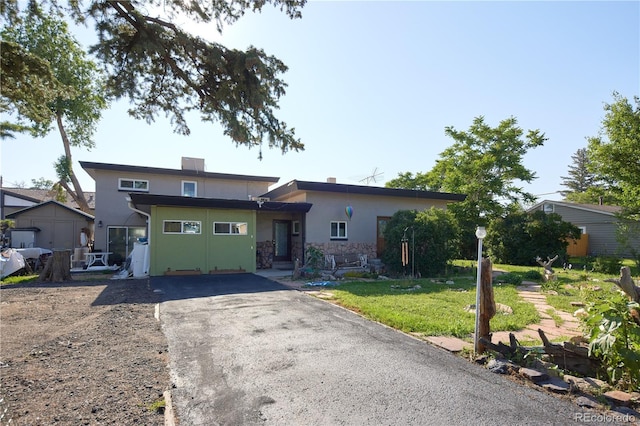 1075 S Ames St, Lakewood, CO 80226 - view of front of house with stucco siding, stone siding, driveway, and a front lawn