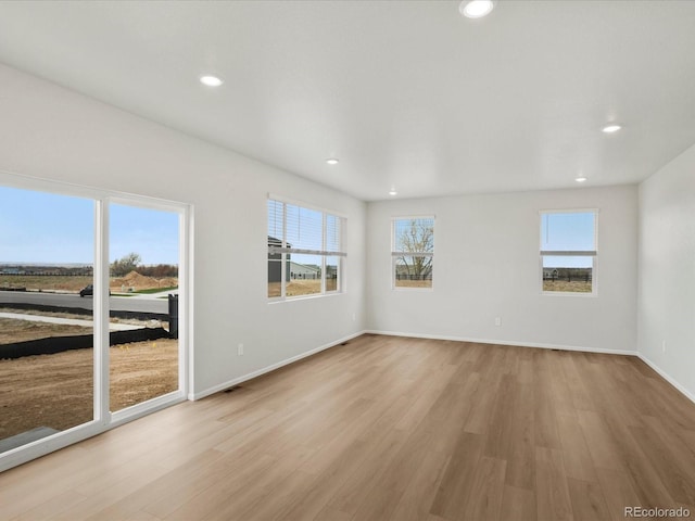 spare room featuring light wood-style flooring, baseboards, and recessed lighting