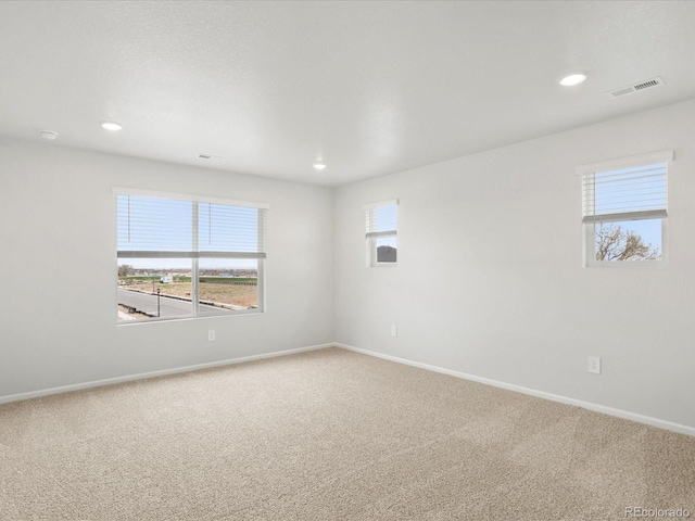 carpeted spare room featuring baseboards and recessed lighting