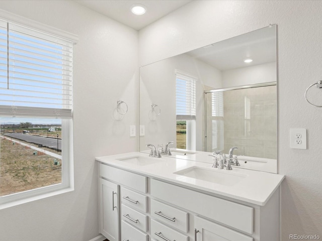 full bath featuring tiled shower and double vanity