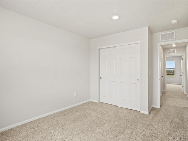 unfurnished bedroom featuring carpet, baseboards, and a closet