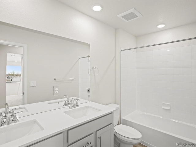 bathroom with toilet, double vanity, bathtub / shower combination, and recessed lighting