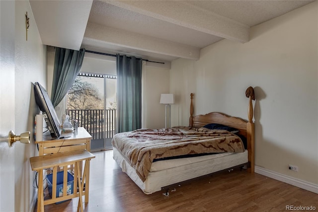 bedroom featuring a textured ceiling, access to outside, and wood-type flooring