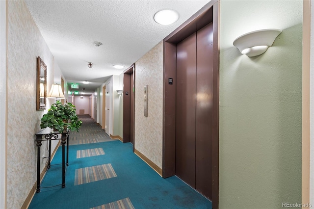 hallway featuring dark carpet, a textured ceiling, and elevator