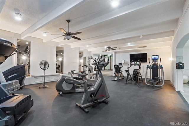 workout area with ceiling fan and a textured ceiling