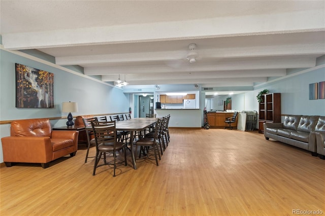 dining room with light hardwood / wood-style flooring and beamed ceiling