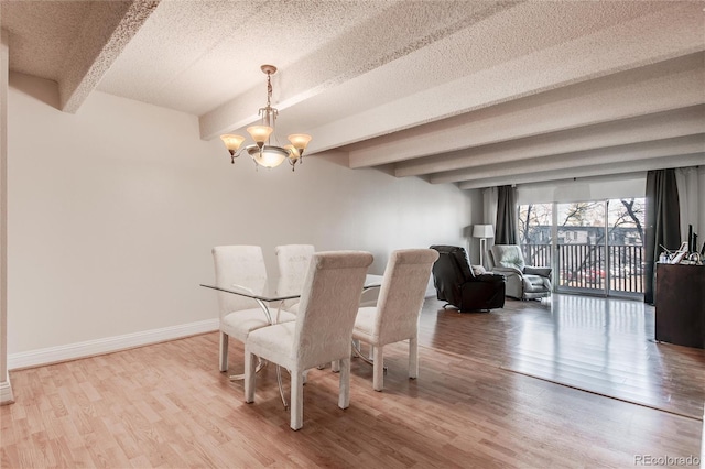 dining area featuring light wood-type flooring, beamed ceiling, a chandelier, and a textured ceiling