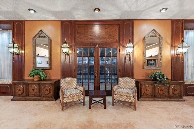 living area with a textured ceiling and light carpet