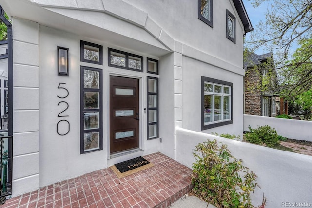 property entrance featuring stucco siding and a porch