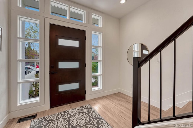 entrance foyer with baseboards, light wood finished floors, recessed lighting, and stairs