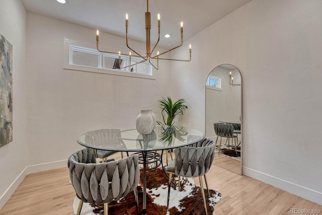 dining area with wood finished floors, baseboards, arched walkways, recessed lighting, and a chandelier