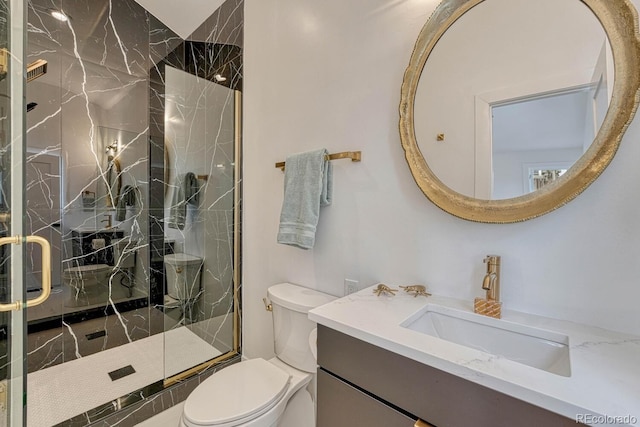 full bath featuring toilet, a marble finish shower, and vanity
