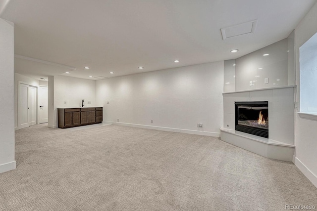 unfurnished living room featuring light carpet, baseboards, recessed lighting, and a tile fireplace