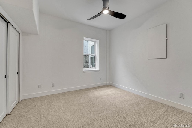 unfurnished bedroom featuring light colored carpet, baseboards, and a closet