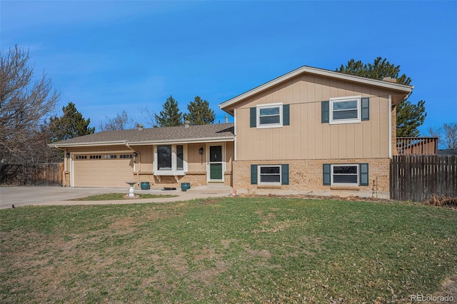 tri-level home with brick siding, an attached garage, and fence