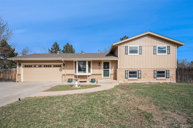 split level home with brick siding, concrete driveway, a front lawn, and fence