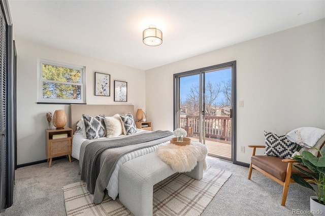 bedroom featuring baseboards, light carpet, and access to exterior