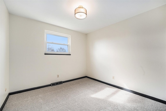 unfurnished room with visible vents, baseboards, and carpet floors