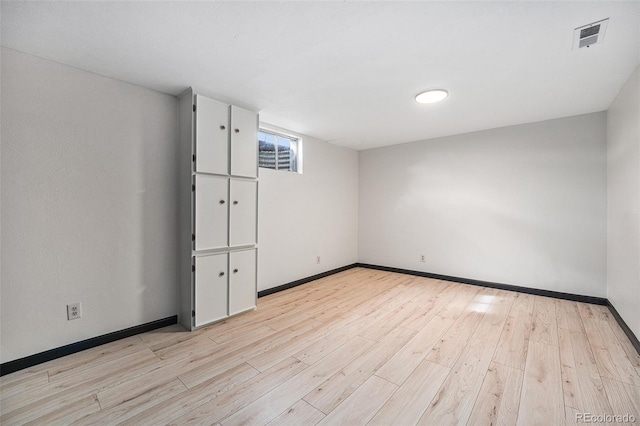 spare room with visible vents, light wood-type flooring, and baseboards