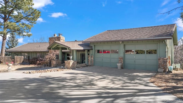 ranch-style house featuring a chimney, concrete driveway, fence, a garage, and a tiled roof