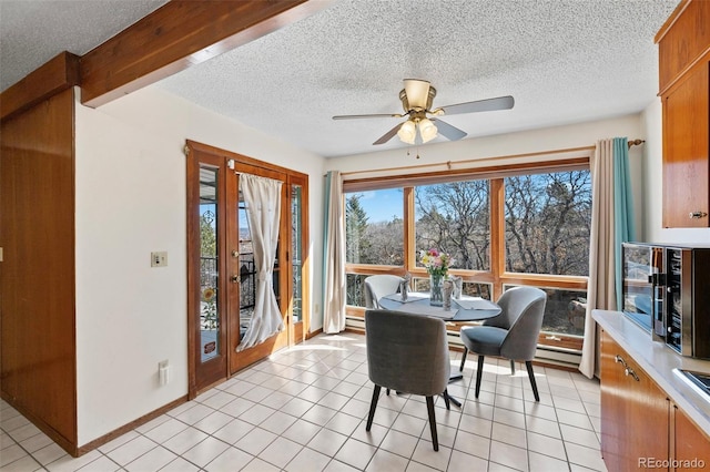 dining space with a textured ceiling and light tile patterned flooring